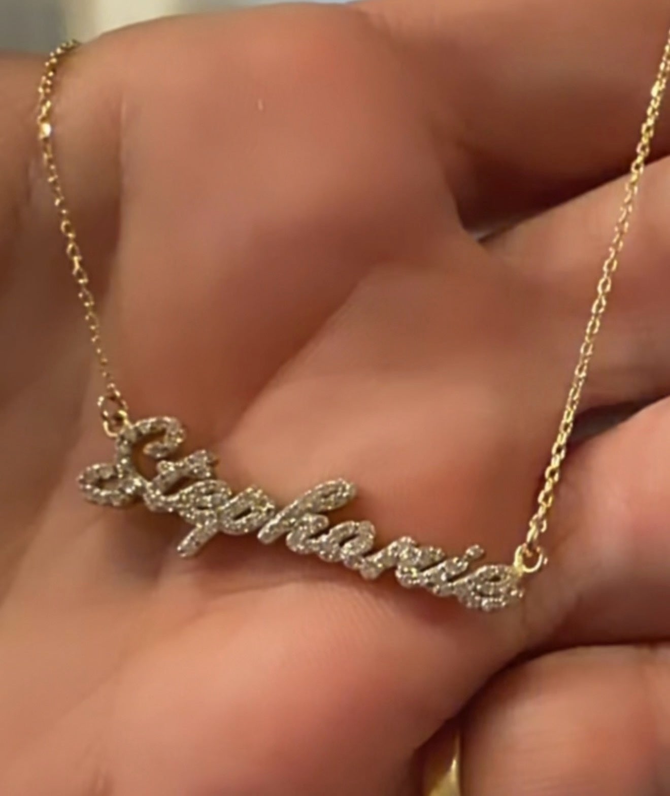 Collar con nombre personalizado Dana Solid Gold en oro con circonitas brillantes sobre una mano