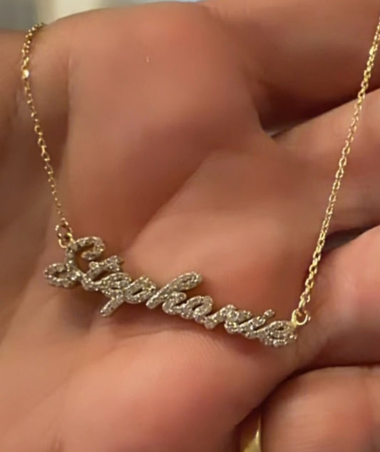 Collar con nombre personalizado Dana Solid Gold en oro con circonitas brillantes sobre una mano